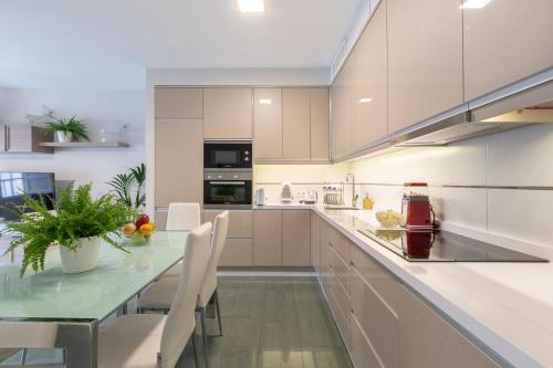 a kitchen with a glass table and white cabinets at Apartamentos Circulo De Artistas in Ronda