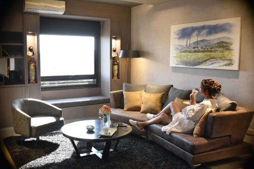a woman sitting on a couch in a living room at Garden Plaza in San Miguel de Tucumán