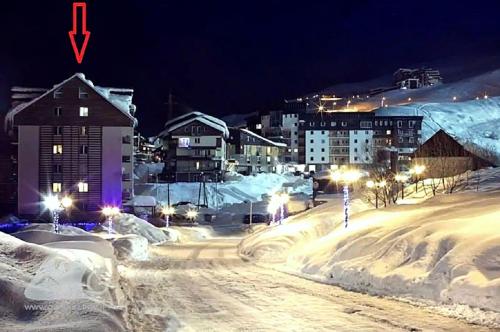 a city covered in snow at night with street lights at "Gudauri Heart" Apartment in Gudauri