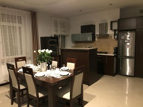 kuchnia ze stołem i krzesłami oraz kuchnia z lodówką w obiekcie Apartment Family Krakow w Krakowie