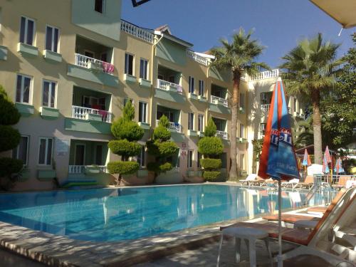 a hotel with a swimming pool in front of a building at Club Sunset Apartments in Marmaris