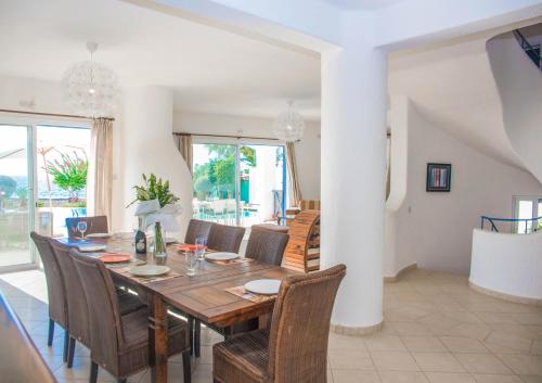 a dining room with a wooden table and chairs at Luxury Seaview Apollo Beach Villa in Paphos