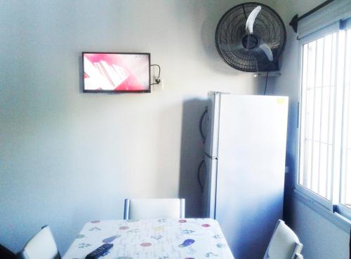 格塞尔镇Sol y Sombra的厨房配有桌子、冰箱和风扇