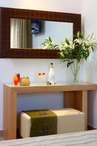 a table with a green suitcase and a mirror at Matogianni Hotel in Mýkonos City
