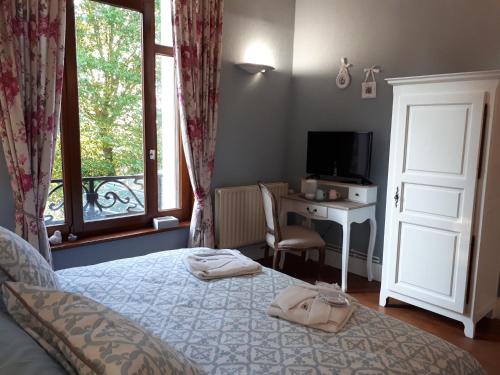 CaudryにあるLe Manoir de la mantilleのベッドルーム1室(ベッド1台、デスク、窓付)