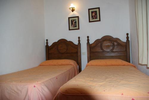 a bedroom with two beds and two pictures on the wall at Casa Abuela María in Isora