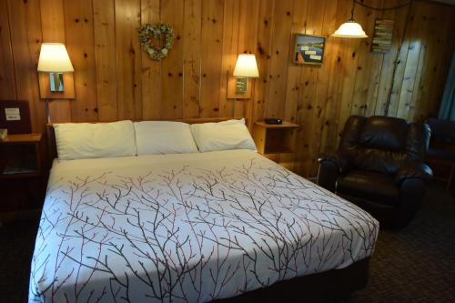 a bedroom with a bed and a chair at Park Motel and Cabins in Florence