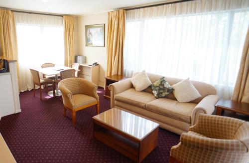 a living room with a couch and a table at Cornwall Park Motor Inn in Auckland