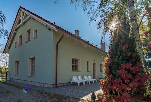 a white house with white chairs and a tree at Casa Mia XIX-w Nadmorski Dom z ogrodem in Cedry Małe