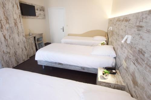 a hotel room with three beds and a desk at Il Piccolo Mondo in Luxembourg