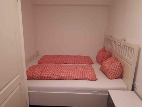 Habitación pequeña con 2 camas y almohadas rojas. en Loetje, en Gosau