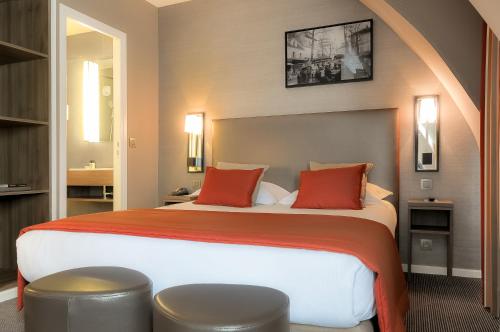 a hotel room with a large bed with red pillows at Hôtel Marais Bastille in Paris