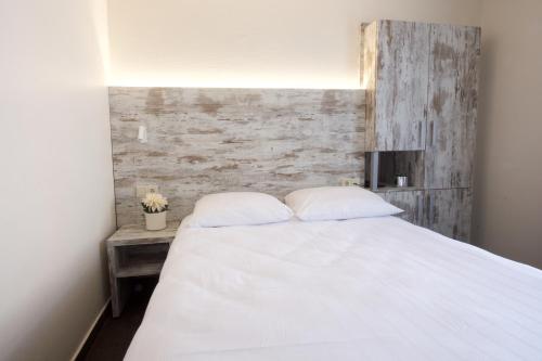 a bed with white sheets and pillows in a bedroom at Il Piccolo Mondo in Luxembourg