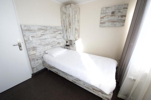a bedroom with a white bed and a brick wall at Il Piccolo Mondo in Luxembourg