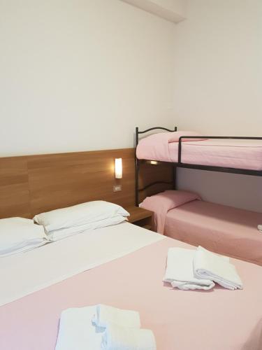 two beds in a room with two bunk beds at Hotel De La Plage in Rimini