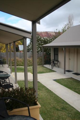 a patio with tables and chairs in a yard at Millthorpe Motel in Millthorpe