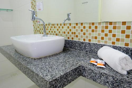 a bathroom with a sink and a towel on a counter at Hotel Encantos de Penedo Alagoas in Penedo