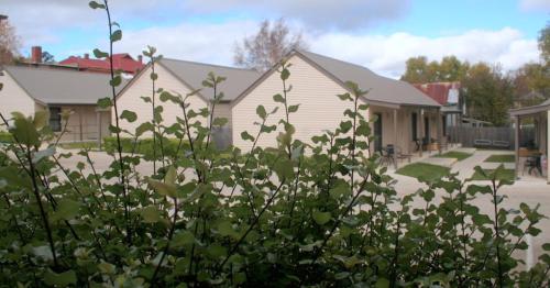 a house with a bush in front of a house at Millthorpe Motel in Millthorpe