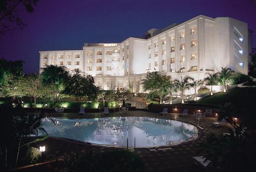 a large building with a large swimming pool at night at Taj Deccan in Hyderabad