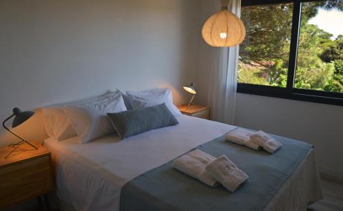 1 dormitorio con 1 cama con 2 toallas en El viejo jardín en Villa Gesell