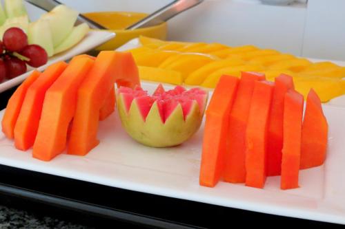 a plate of fruit and vegetables on a table at Hotel Encantos de Penedo Alagoas in Penedo