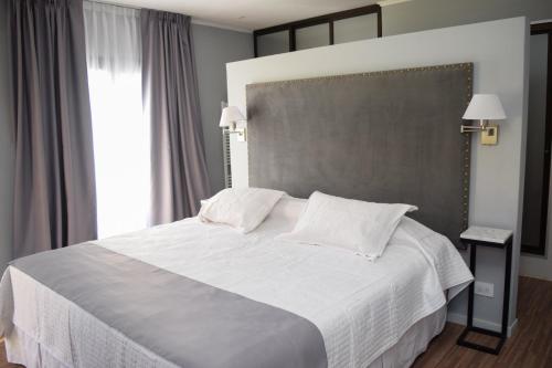 1 dormitorio con cama blanca y ventana grande en HYN Hotel Boutique en 