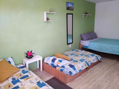 a room with two beds and a mirror at Casita Típica Cholulteca - Completa (8 prs) in Cholula