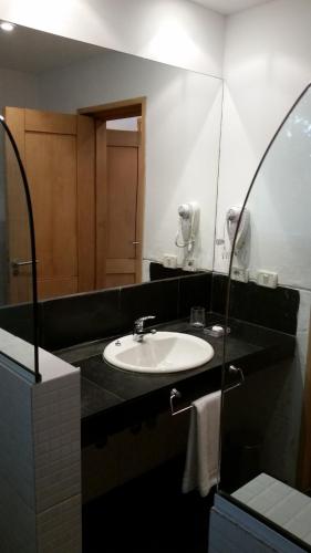 a bathroom with a sink and a mirror at Posada de los Pajaros in Punta del Este