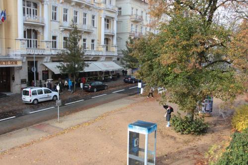 a person standing on a city street with a pay phone at Penzion u Pidly in Mariánské Lázně