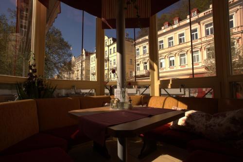 a dining room with a table and a large window at Penzion u Pidly in Mariánské Lázně