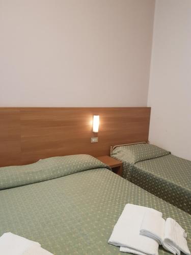 two beds in a hotel room with towels on them at Hotel De La Plage in Rimini