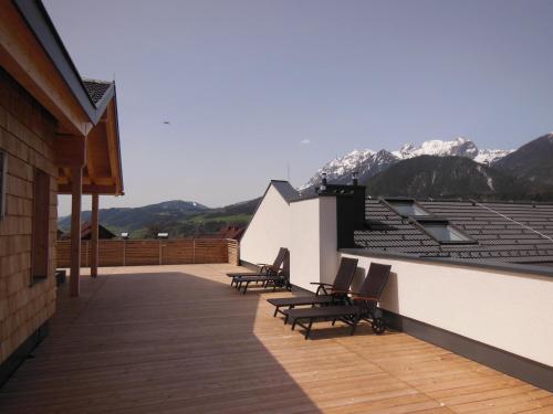 a balcony with chairs and mountains in the background at Penthouse Alpine Living direkt an der Skipiste by Schladmingurlaub in Haus im Ennstal