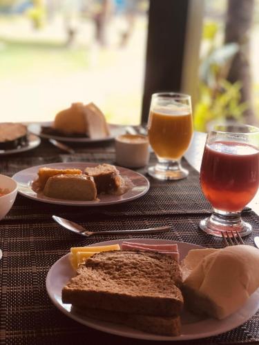 un tavolo con piatti di cibo e due bicchieri di birra di Pousada Maraoka a Porto De Galinhas