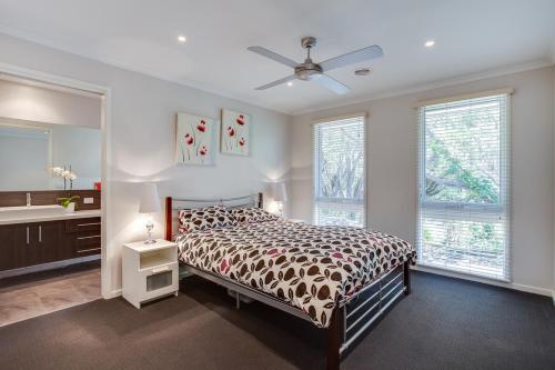 a bedroom with a bed and two windows at Phil's Family Holidays in Rye