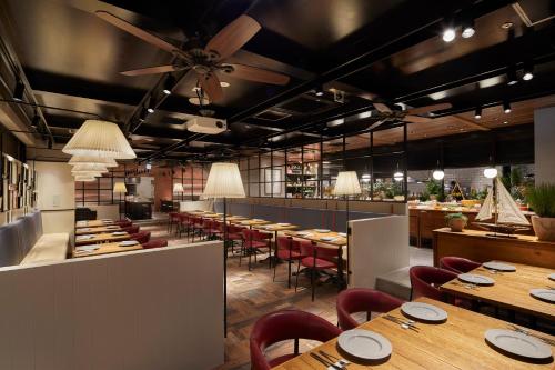 a restaurant with wooden tables and red chairs at Keio Prelia Hotel Kyoto Karasuma-Gojo in Kyoto