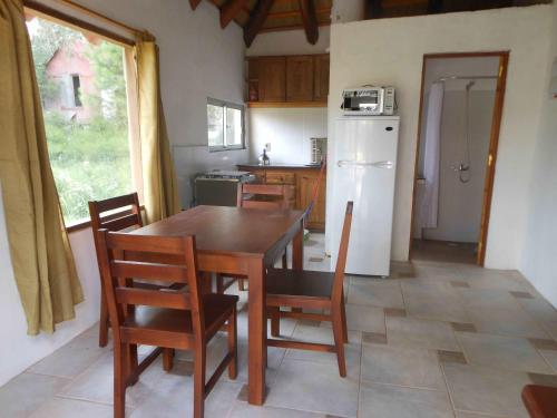 a kitchen with a table and chairs and a refrigerator at El Quincho in San Luis