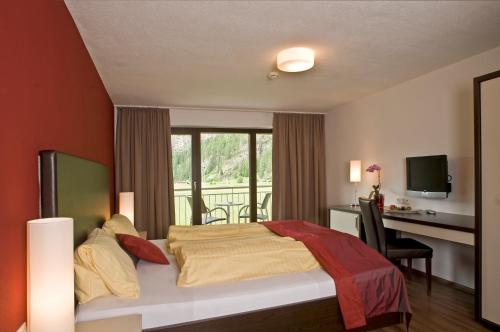 sypialnia z łóżkiem, biurkiem i oknem w obiekcie Hotel Bergwelt w Langenfeld