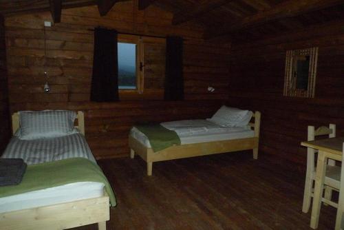 ein Zimmer mit zwei Betten in einer Blockhütte in der Unterkunft Lax-á Greenland Camp in Qassimiut