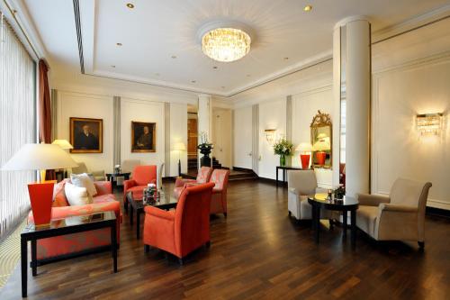 a lobby with couches and tables and chairs at Kastens Hotel Luisenhof in Hannover