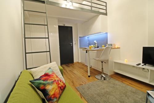 a living room with a green couch and a desk at Aparthotel Tectum TectumApartments in Wrocław