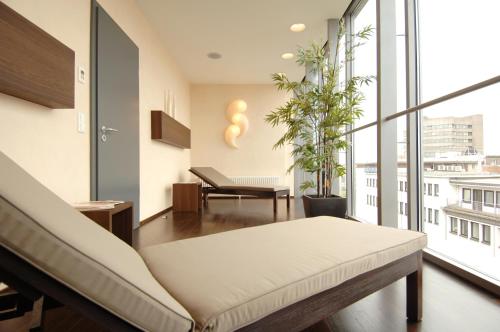 a living room with a couch and a large window at Kastens Hotel Luisenhof in Hannover