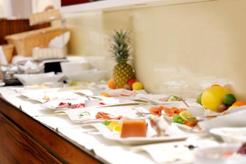a buffet with many plates of food on a table at Kastens Hotel Luisenhof in Hannover