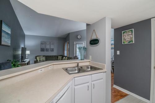 a kitchen with a sink and a living room at o CHARMING CONDO MINUTES FROM GORGEOUS CLEARWATER BEACHES o in Clearwater