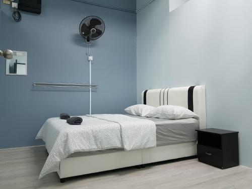 - une chambre dotée d'un lit avec un mur bleu dans l'établissement SS Homestay Borneo Housing SL3A, à Kuching