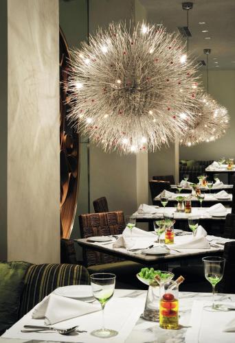 a dining room with white tables and a chandelier at Taj Bengal in Kolkata