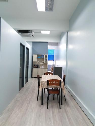 a dining room with a table and chairs and a kitchen at SS Homestay Borneo Housing SL4A in Kuching