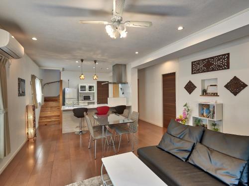 a living room and kitchen with a couch and a table at The Pool Resort Villa Hasta Manana in Onna