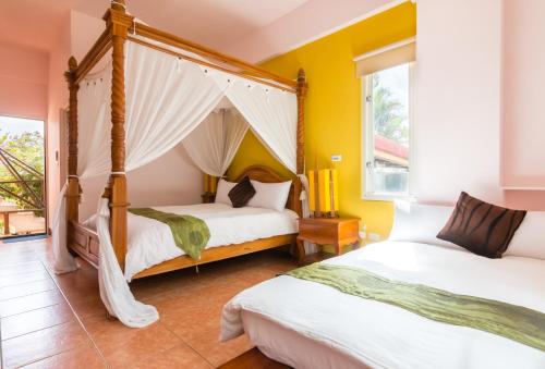 2 camas en una habitación con paredes amarillas en Bali Lover, en Jian