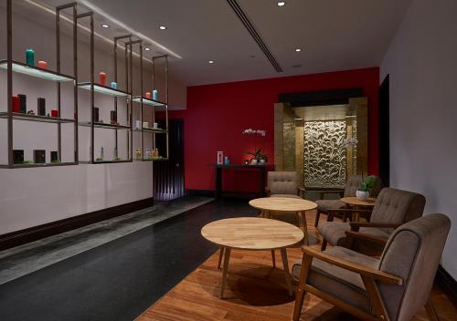 a restaurant with two tables and chairs and red walls at Pullman Kuala Lumpur City Centre Hotel & Residences in Kuala Lumpur
