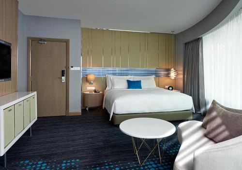 a hotel room with a bed and a couch at Pullman Kuala Lumpur City Centre Hotel & Residences in Kuala Lumpur